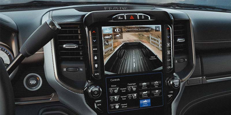 View of the rear backup camera and other safety features displayed on the infotainment system screen in a 2024 RAM 3500 HD