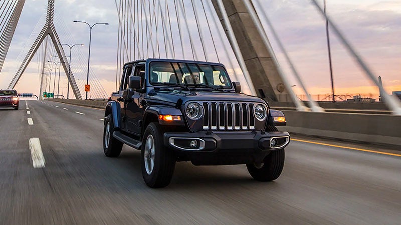 Front view of 2023 Jeep Wrangler Unlimited driving down highway