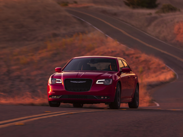 Red Chrysler 300 traveling down desert highway