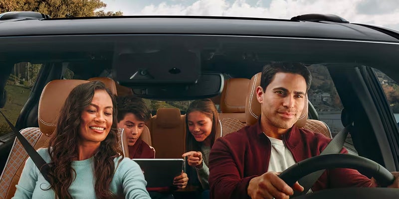 A family of four driving in their new Chrysler vehicle
