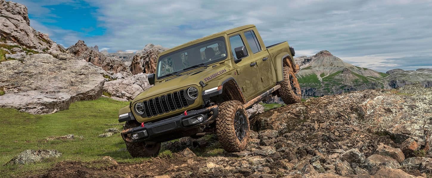 2026 Jeep Gladiator Rubicon X climbing a rocky muddy trail, the kind of use that calls for Jeep service in Bowie, TX